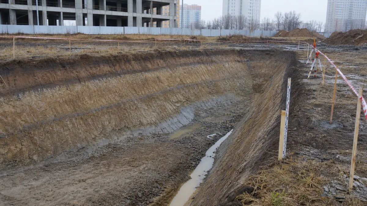Откосы котлована с водоотводом, ограждением бровки и геодезическим контролем
